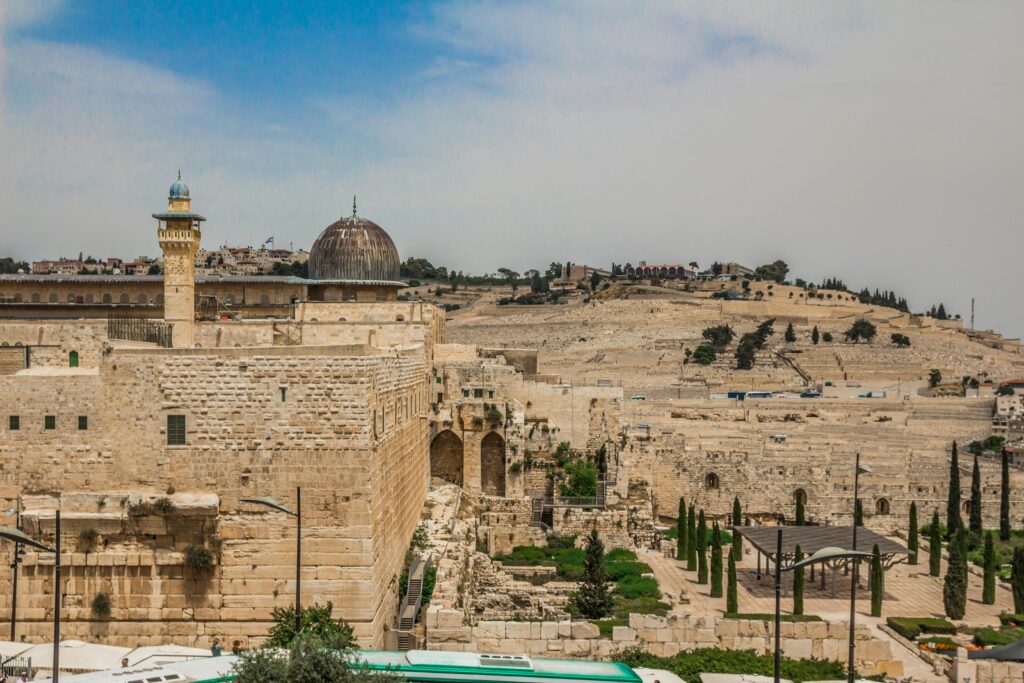 View of ancient Islamic architecture in Jerusalem with stone walls and domes under a clear sky.